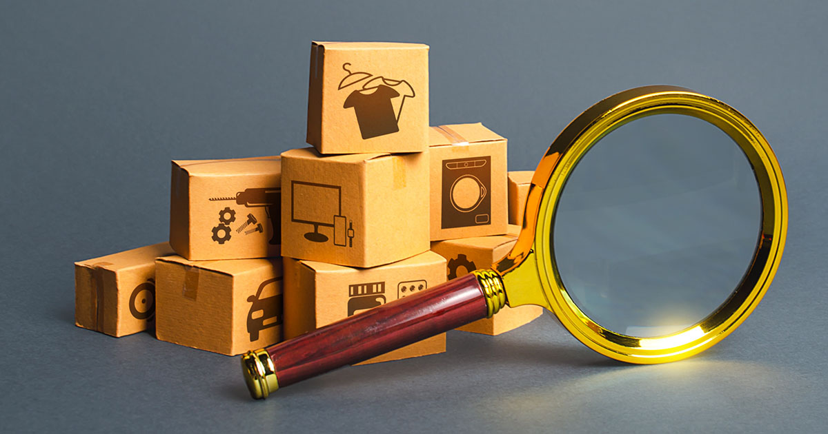 Magnifying glass in front of small cardboard boxes with product labels on them.