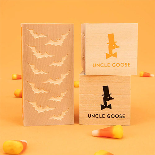 Wooden letter blocks with flying bats pattern embossed on the side.