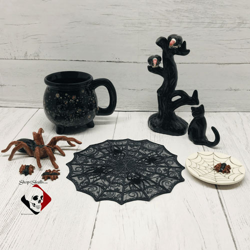 Black spiderweb doily with other ceramic Halloween decorations.
