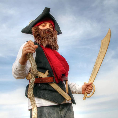 Kid dresses as pirate with wooden sabre and pistol.