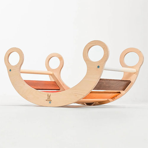 Wooden rocker toy in soft autumn colors.