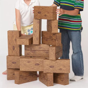 Children playing and building with giant cardboard building blocks with wood pattern.