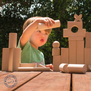 Young boy playing with wooden building blocks.