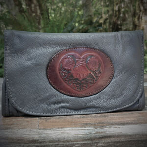 Black leather clutch with inlaid leather medallion showing Celtic flowers.