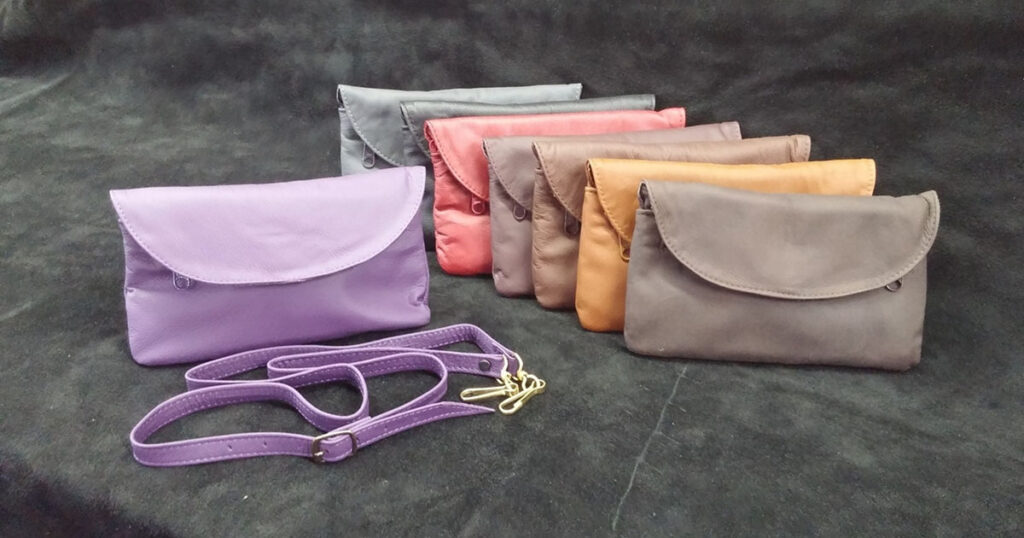 Assortment of leather women's wallets with optional shoulder straps by Ace Leather Goods.
