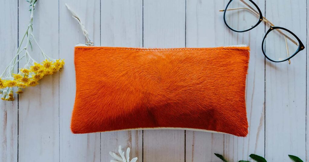 Women's clutch wallet made from soft, fur orange fabric by Crystalyn Kae.