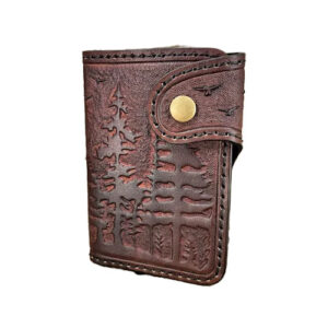Brown leather wallet with spooky forest design carved into it.