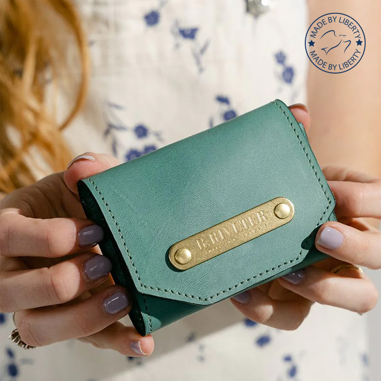 Image of woman holding small leather women's wallet.