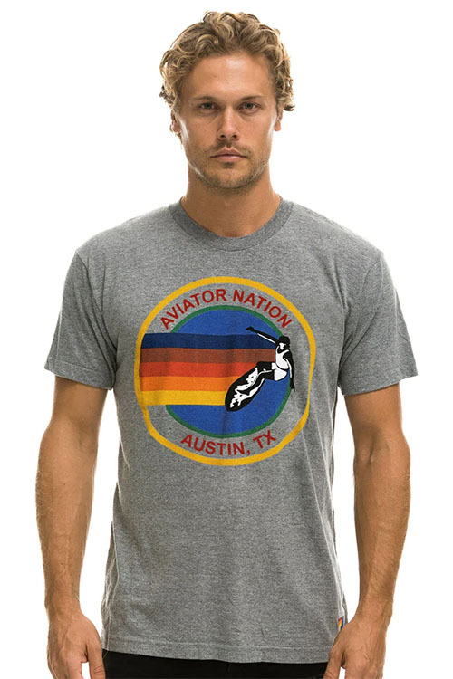 Man wearing grey t-shirt with Aviator Nation logo.