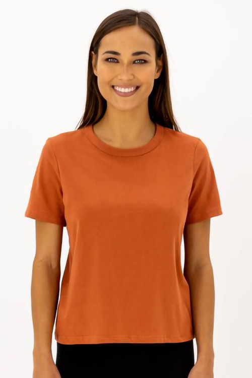 Smiling woman wearing dark orange t-shirt.