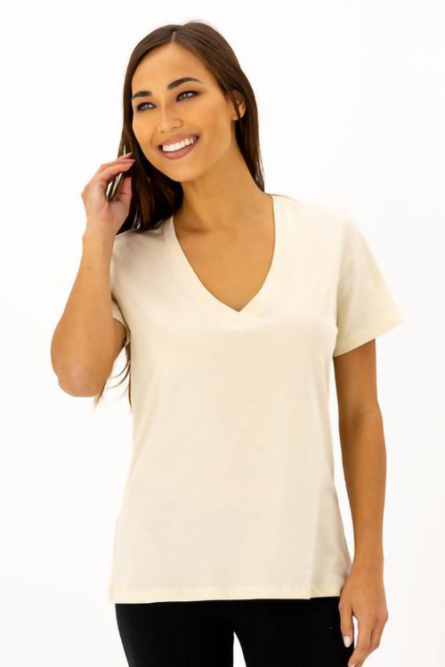 Smiling woman wearing broken white deep v-neck t-shirt.