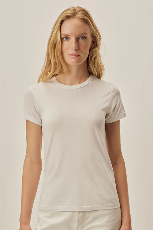 Woman wearing long white crew-neck t shirt.