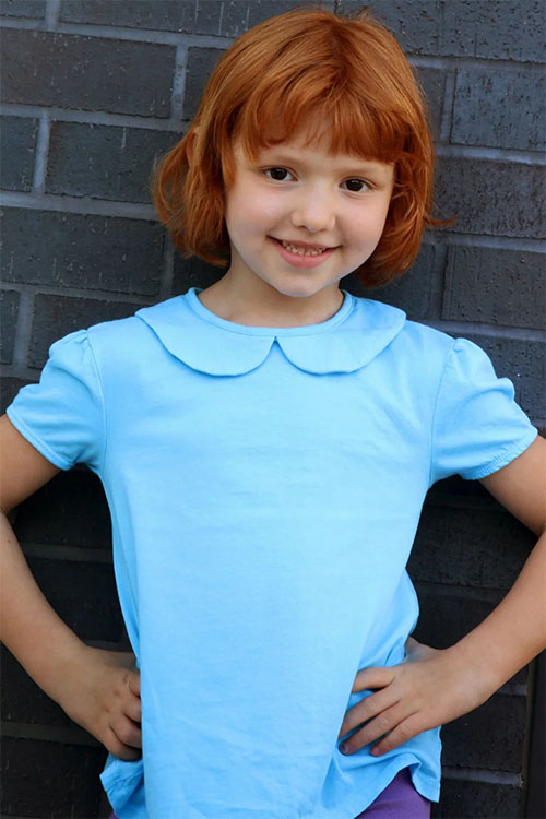 Girl wearing light blue t-shirt with Peter Pan collar.