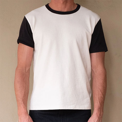 Man wearing white crew neck t-shirt with black sleeves.