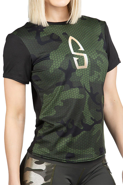 Woman wearing t-shirt with green and black camo pattern.