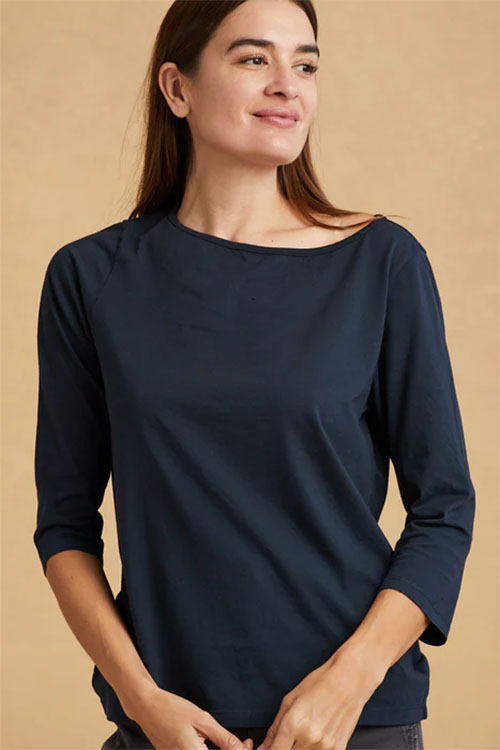 Woman wearing dark blue t-shirt with 3/4 sleeves and boat collar.