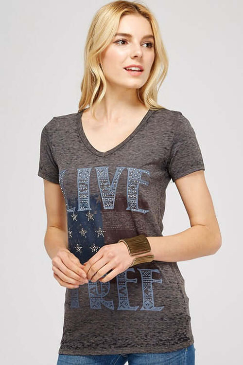 Woman wearing dark-grey t-shirt with v-neck, short sleeves and American flag print on the front with words 'live free'.