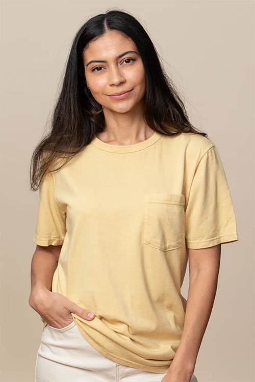 Woman wearing light yellow crew-neck t-shirt with front pocket.