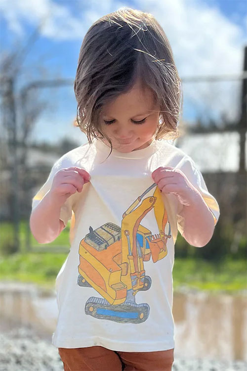 Young girl wearing white t-shirt with yellow crane drawing. 