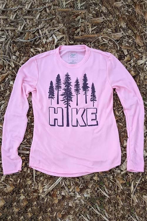 Pink athletic crew-neck t-shirt with long sleeves ,and pine trees and the word hike printed on the chest.