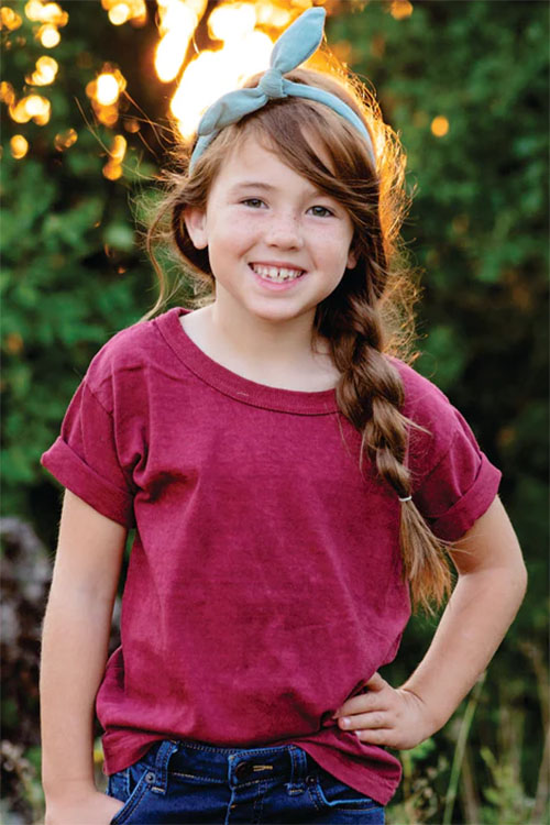 Young girl wearing red short sleeve t-shirt.