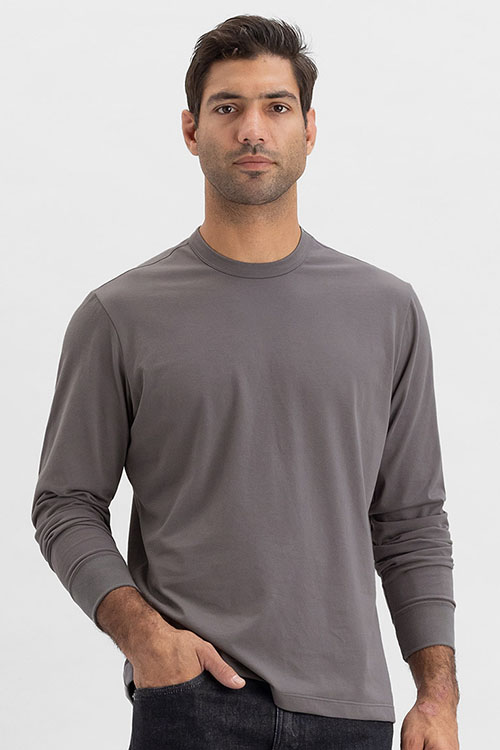 Man wearing dark grey t-shirt with crew-neck and long sleeves.