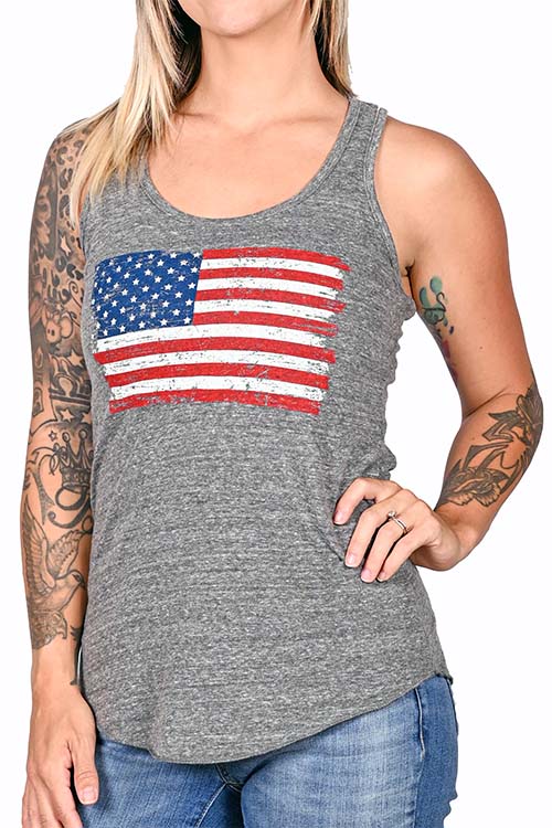 Woman wearing grey tank top with colored American flag print on the chest.