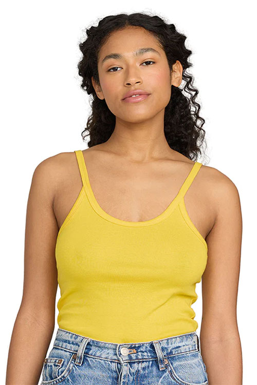 Woman wearing yellow tank top with scoop neck and spaghetti straps.